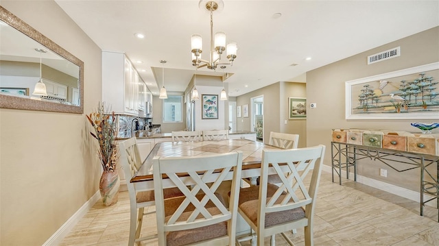 dining space with light tile patterned flooring and an inviting chandelier