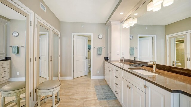 bathroom with dual vanity and tile patterned floors