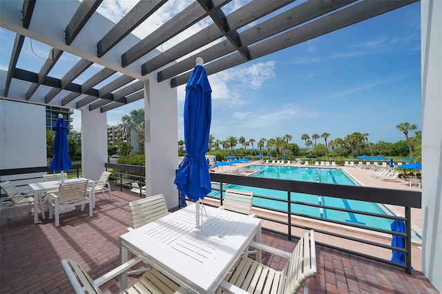 wooden deck with a patio, a community pool, and a pergola