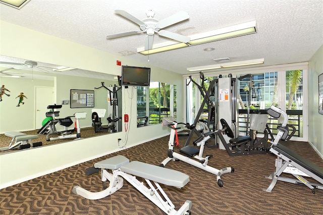 exercise room with a healthy amount of sunlight, a textured ceiling, ceiling fan, and carpet flooring