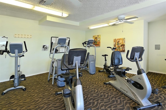 workout area featuring carpet, ceiling fan, and a textured ceiling