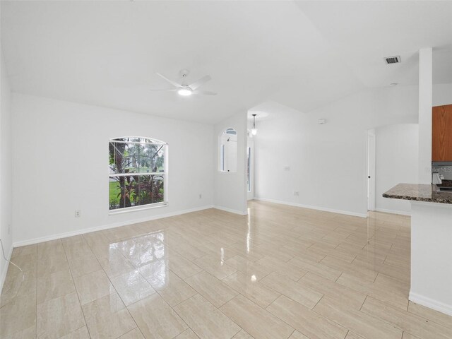 unfurnished living room featuring light tile patterned flooring, vaulted ceiling, and ceiling fan