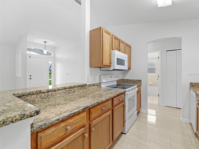 kitchen featuring light stone counters, white appliances, and light tile patterned floors