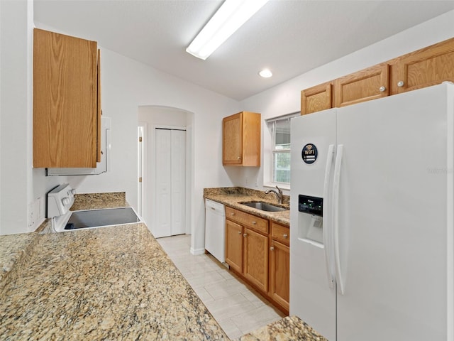 kitchen with light stone counters, sink, white appliances, and light tile patterned floors