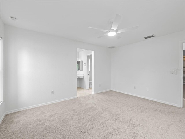 spare room with ceiling fan and light colored carpet