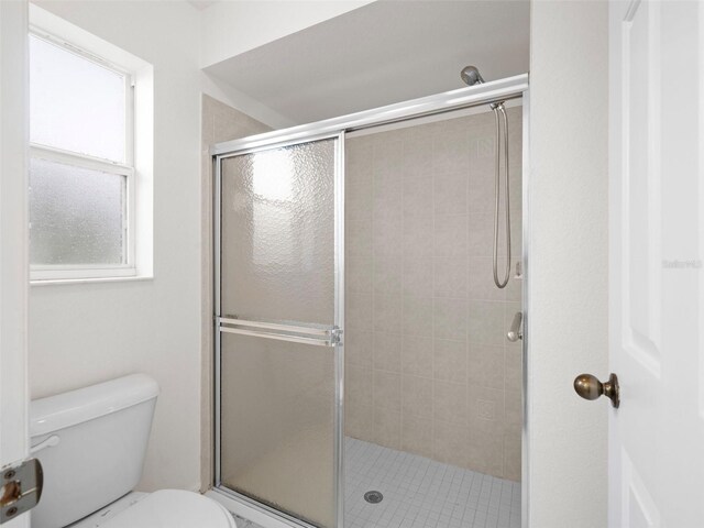 bathroom with toilet and an enclosed shower