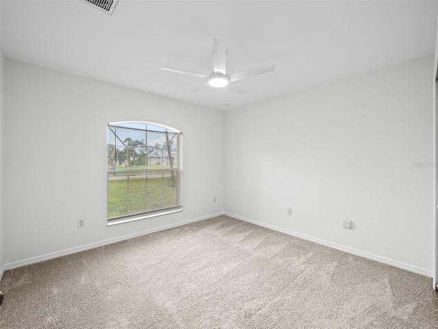 carpeted spare room featuring ceiling fan