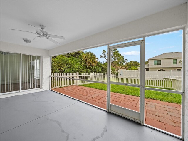 unfurnished sunroom featuring ceiling fan