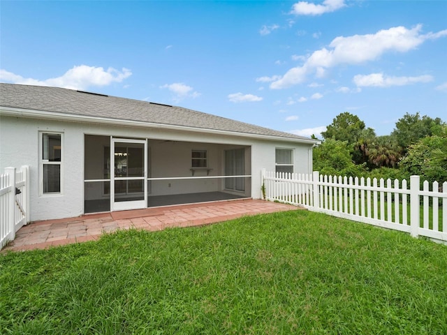 back of house with a yard and a sunroom