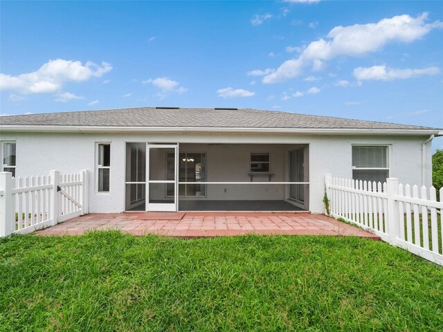 rear view of house with a patio and a lawn