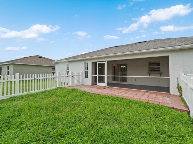 back of house featuring a lawn and a patio area