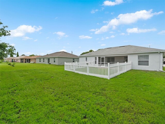 rear view of property featuring a yard