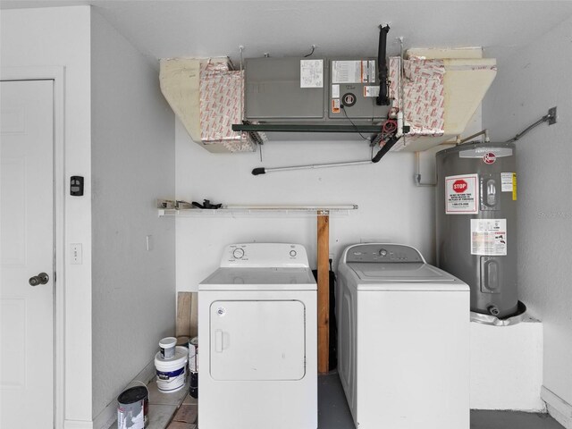 washroom with water heater, independent washer and dryer, and tile patterned flooring