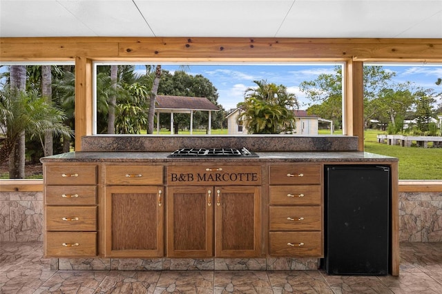 kitchen featuring fridge and black gas stovetop