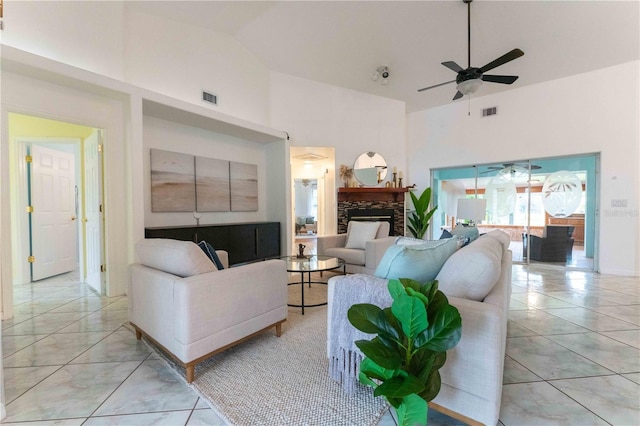 living room featuring a fireplace, high vaulted ceiling, and ceiling fan