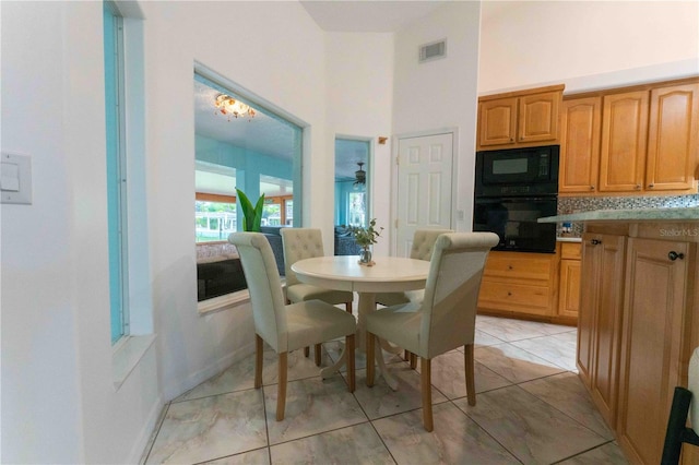 dining space featuring a towering ceiling