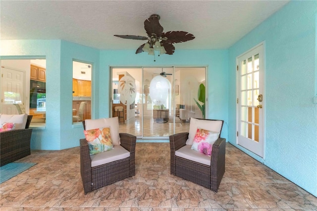 living area featuring a textured ceiling and ceiling fan