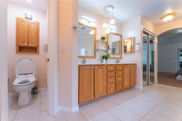 bathroom with toilet, vanity, and tile patterned flooring