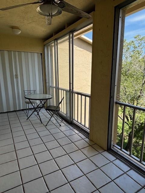 unfurnished sunroom with ceiling fan