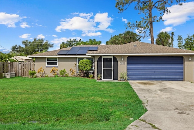 ranch-style house featuring solar panels, a garage, and a front lawn