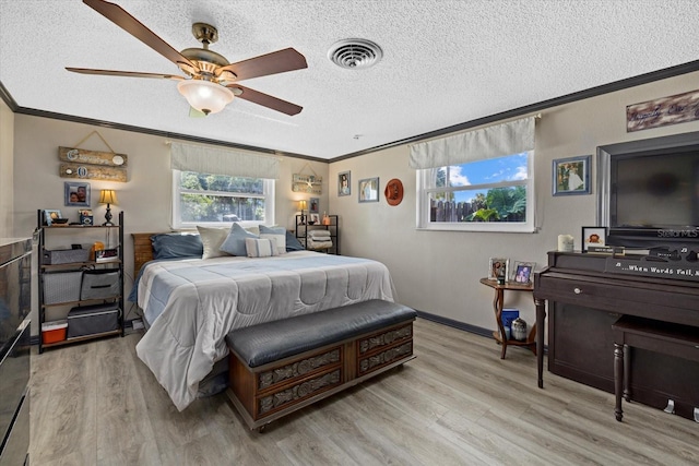 bedroom with light wood finished floors, multiple windows, visible vents, and ornamental molding