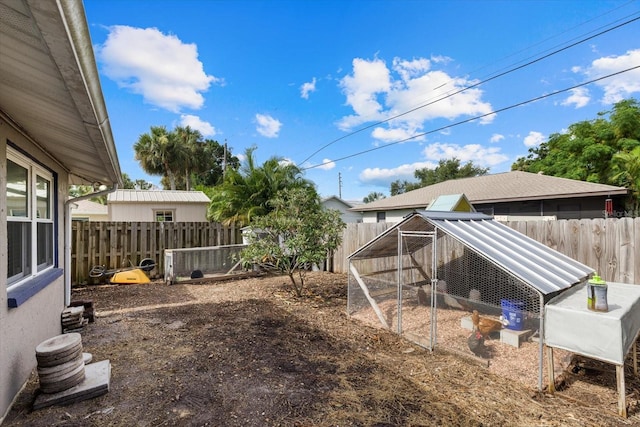 view of yard with an outbuilding, a fenced backyard, and exterior structure