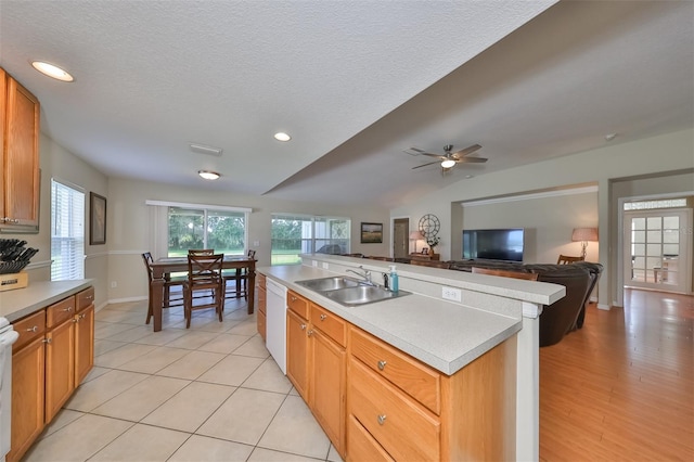 kitchen featuring white dishwasher, sink, a healthy amount of sunlight, and a kitchen island