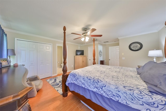 bedroom with hardwood / wood-style flooring, ornamental molding, ceiling fan, and a closet