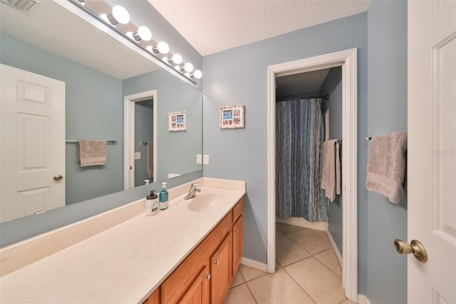 bathroom with vanity, tile patterned floors, and a textured ceiling