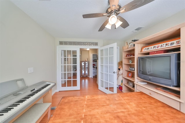 interior space with hardwood / wood-style floors, a textured ceiling, ceiling fan, and french doors