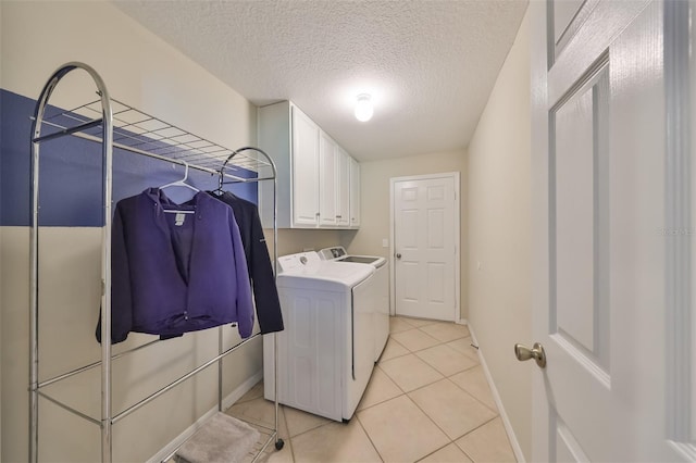 clothes washing area featuring light tile patterned floors, washer and dryer, and a textured ceiling