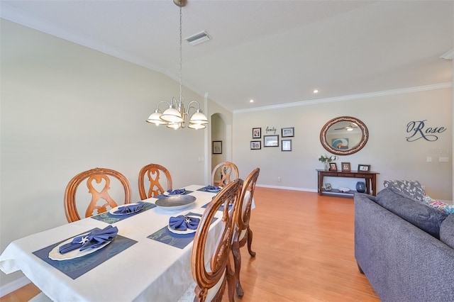 11622 Summit Rock Ct, Parrish, FL 34219 - dining area with arched walkways, a chandelier, light wood-style floors, ornamental molding, and baseboards