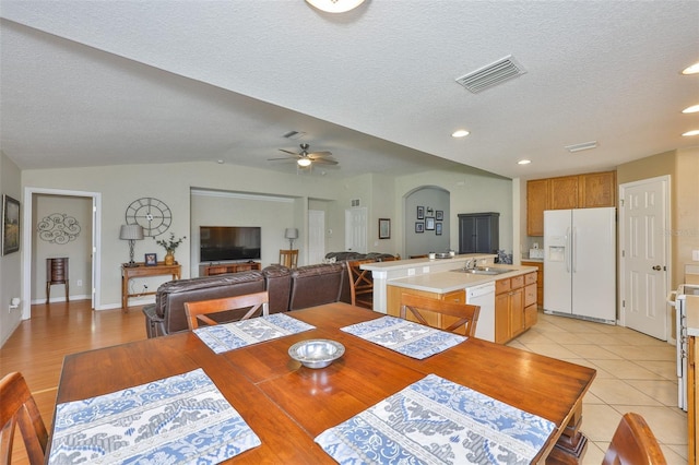 11622 Summit Rock Ct, Parrish, FL 34219 - dining space featuring lofted ceiling, a textured ceiling, a ceiling fan, light tile patterned floors, and baseboards
