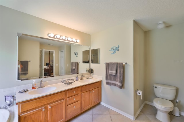 11622 Summit Rock Ct, Parrish, FL 34219 - full bathroom with double vanity, tile patterned floors, toilet, a textured ceiling, and baseboards