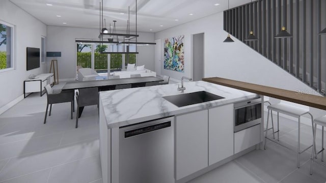 kitchen with a center island with sink, sink, decorative light fixtures, stainless steel dishwasher, and white cabinetry