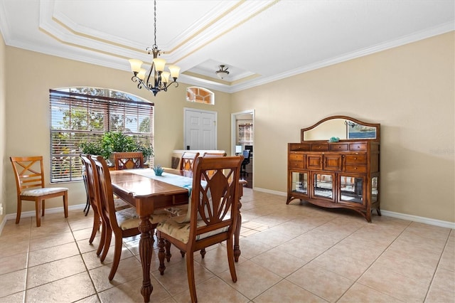 tiled dining room with a raised ceiling, crown molding, and an inviting chandelier