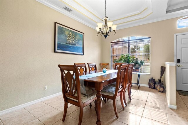 tiled dining space featuring a chandelier, a tray ceiling, and ornamental molding