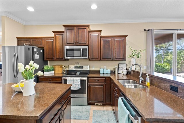 kitchen featuring light tile patterned flooring, sink, crown molding, and stainless steel appliances