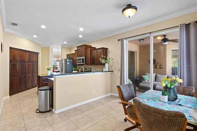 kitchen with ornamental molding, ceiling fan, light tile patterned floors, and stainless steel appliances