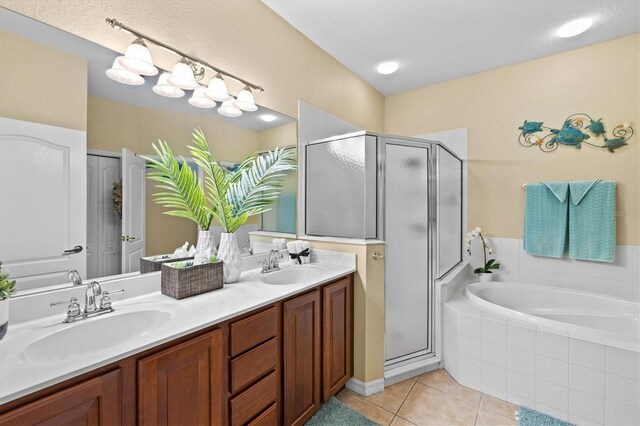 bathroom with a textured ceiling, separate shower and tub, tile patterned flooring, and double sink vanity