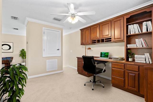 carpeted office space featuring a textured ceiling, ceiling fan, built in desk, and ornamental molding