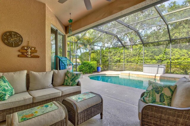 view of pool with a patio, ceiling fan, glass enclosure, and an outdoor hangout area