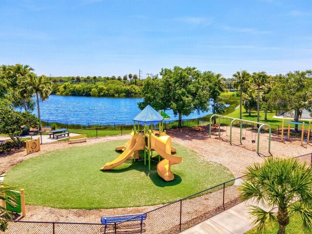 view of jungle gym featuring a water view and a lawn