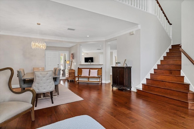 dining room with crown molding, hardwood / wood-style floors, and a notable chandelier