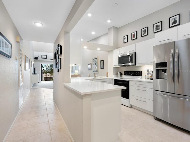 kitchen with stainless steel appliances, sink, white cabinets, light colored carpet, and kitchen peninsula