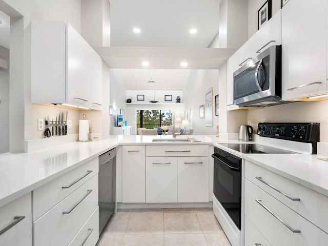 kitchen featuring appliances with stainless steel finishes, light tile patterned floors, sink, and white cabinetry