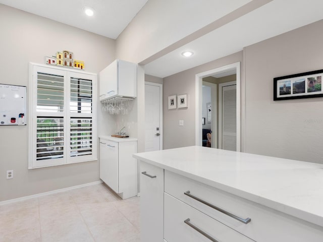 kitchen with light tile patterned floors and white cabinetry