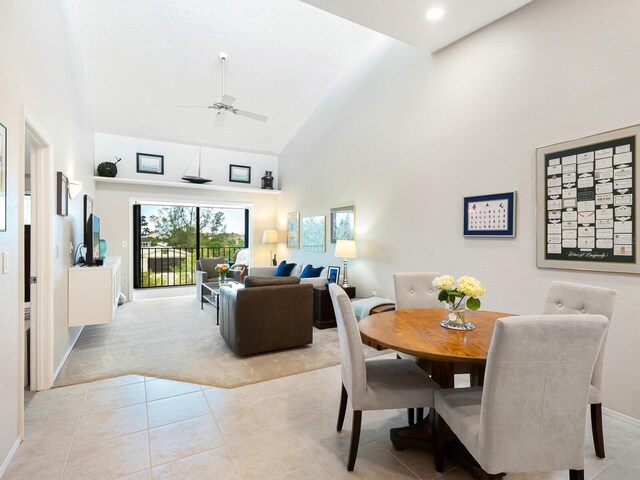 dining room featuring ceiling fan, high vaulted ceiling, and light tile patterned floors