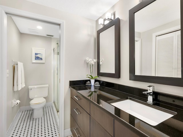 bathroom featuring a shower with door, vanity, tile patterned flooring, and toilet