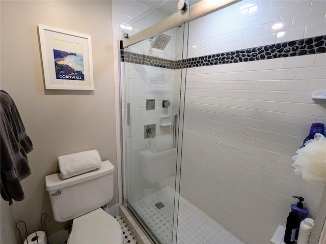 bathroom with a shower with shower door and toilet